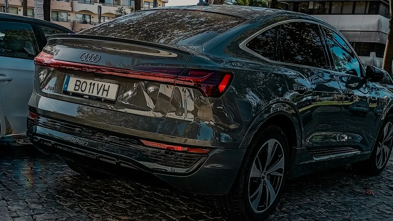 SUV électrique premium gris foncé vu de trois quarts arrière, bandeau de feux arrière LED