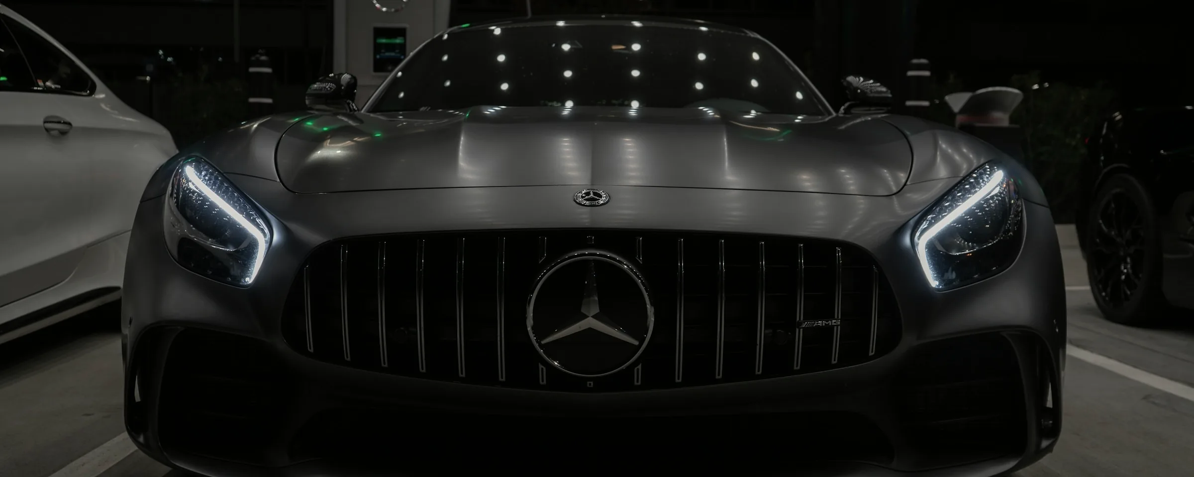 Détail des phares avant LED d'un coupé premium gris mat, de nuit